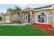 Tan brick house with dark brown door, solar panels, and manicured lawn at 1546 Thornhill Cir, Oviedo, FL 32765