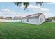 House's backyard with a grassy lawn and solar panels at 1546 Thornhill Cir, Oviedo, FL 32765