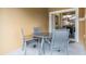 Small patio with a glass-top table and four gray chairs at 8947 Bismarck Palm Rd, Kissimmee, FL 34747