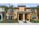 Tan two-story house with a covered entryway and landscaping at 8947 Bismarck Palm Rd, Kissimmee, FL 34747