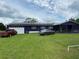 Purple house with solar panels, a large yard, and two cars parked in front at 4805 Hunting Lodge Dr, Saint Cloud, FL 34772