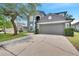 Two-story house with gray siding, two-car garage, and landscaped yard at 4741 Park Eden Cir, Orlando, FL 32810