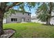 Spacious backyard with a two-story house, grass, and large trees at 4741 Park Eden Cir, Orlando, FL 32810