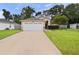 Tan house with attached garage and driveway at 9920 4Th Ave, Orlando, FL 32824
