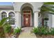 Inviting front porch with red door, columns, and landscaping at 372 Hinsdale Dr, Debary, FL 32713