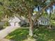 Two-story house with double garage, lush landscaping, and large tree at 372 Hinsdale Dr, Debary, FL 32713