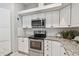 White kitchen cabinets, granite countertops, stainless steel appliances and a microwave at 372 Hinsdale Dr, Debary, FL 32713