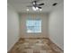 Spacious bedroom with tile flooring, ceiling fan, and large window at 7465 Excitement Dr, Reunion, FL 34747