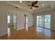 Main bedroom with hardwood floors, access to balcony, and two walk-in closets at 7465 Excitement Dr, Reunion, FL 34747