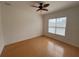 Spacious bedroom with hardwood floors, ceiling fan, and large window at 7465 Excitement Dr, Reunion, FL 34747