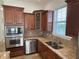 Modern kitchen with stainless steel appliances and wood cabinets at 7465 Excitement Dr, Reunion, FL 34747