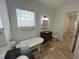 Bathroom with clawfoot tub, wood vanity, and tile floor at 7465 Excitement Dr, Reunion, FL 34747