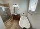 Bathroom features a soaking tub, walk-in shower, and wood vanity at 7465 Excitement Dr, Reunion, FL 34747