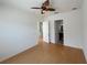 Bedroom with hardwood floor, ceiling fan, and door to en-suite bathroom at 7465 Excitement Dr, Reunion, FL 34747