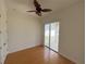 Bedroom with hardwood floors, ceiling fan and access to balcony at 7465 Excitement Dr, Reunion, FL 34747