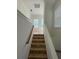 Indoor stairs leading to upper level, tile steps and wooden handrail at 7465 Excitement Dr, Reunion, FL 34747