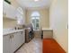 Convenient laundry room with washer, dryer, sink, and built-in cabinets at 256 New Gate Loop, Lake Mary, FL 32746