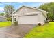 White garage door and driveway of a single-Gathering home at 1021 Embrun Ct, Kissimmee, FL 34759