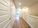 Upstairs hallway with wood-look laminate floors and multiple doors at 7924 Spectrum Dr, Kissimmee, FL 34747