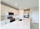Modern kitchen with white cabinets, quartz countertops and stainless steel appliances at 7924 Spectrum Dr, Kissimmee, FL 34747
