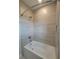 Clean bathroom with a tub and tile surround at 7924 Spectrum Dr, Kissimmee, FL 34747