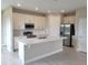 Open kitchen with white cabinets, quartz countertops and stainless steel appliances at 7924 Spectrum Dr, Kissimmee, FL 34747