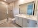 Updated bathroom featuring a double vanity and a walk-in shower at 7924 Spectrum Dr, Kissimmee, FL 34747