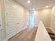 Bright hallway with wood-look laminate floor and access to bedrooms at 7924 Spectrum Dr, Kissimmee, FL 34747