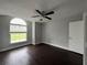 Bright bedroom with dark laminate floors and arched window at 1928 Larkwood Dr, Apopka, FL 32703