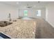 Granite countertop kitchen island with a double sink overlooking the living room at 4197 Sagefield Dr, Harmony, FL 34773