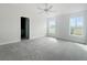Main bedroom with grey carpet, ceiling fan and access to a private bathroom at 4197 Sagefield Dr, Harmony, FL 34773