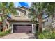 Two story house with a double garage and palm trees at 8869 Rhodes St, Kissimmee, FL 34747