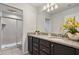 Bathroom with granite countertops, double sinks, and a walk-in shower at 8869 Rhodes St, Kissimmee, FL 34747
