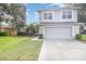Two-story house with gray siding, two-car garage, and a well-maintained lawn at 2807 Strand Loop Ct, Oviedo, FL 32765