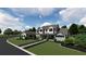 Two-story farmhouse with gray roof, stone accents, and landscaped yard at 405 Long And Winding Rd, Howey In The Hills, FL 34737