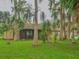 Backyard view of house with screened patio and lush landscaping at 16 Cypress Dr, Eustis, FL 32726