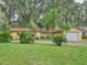 Ranch style home with a white garage door and circular driveway at 16 Cypress Dr, Eustis, FL 32726