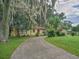 Ranch style home with a circular driveway and lush landscaping at 16 Cypress Dr, Eustis, FL 32726