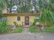 House exterior featuring a yellow facade and lush landscaping at 16 Cypress Dr, Eustis, FL 32726