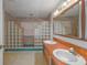 Bathroom with dual vanity, glass block shower, and vintage mirror at 16 Cypress Dr, Eustis, FL 32726