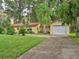 Ranch style home with a white garage door and driveway at 16 Cypress Dr, Eustis, FL 32726