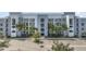 Modern apartment building with ample parking and lush landscaping at 4751 Clock Tower Dr # 105, Kissimmee, FL 34746