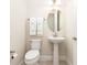 Small bathroom with toilet, pedestal sink, and oval mirror at 3074 Key Lime Loop, Kissimmee, FL 34747