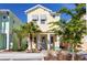 Two-story light yellow house with teal door and shutters at 3074 Key Lime Loop, Kissimmee, FL 34747
