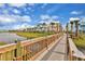 Wooden boardwalk path with lake and homes in the background at 3074 Key Lime Loop, Kissimmee, FL 34747