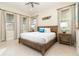 King bedroom with wood platform bed, nightstands, and large windows at 3074 Key Lime Loop, Kissimmee, FL 34747