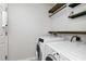 Laundry room with washer, dryer, and ample shelving at 4732 Park Eden Cir, Orlando, FL 32810