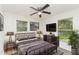 Main bedroom with ceiling fan, TV, and large windows at 500 Glover St, Eustis, FL 32726