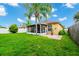 Backyard with screened patio, lush lawn, and a palm tree at 250 White Marsh Cir, Orlando, FL 32824