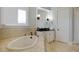 Bathroom with corner bathtub, double vanity, and tile floors at 25602 Grandview Pointe, Sorrento, FL 32776